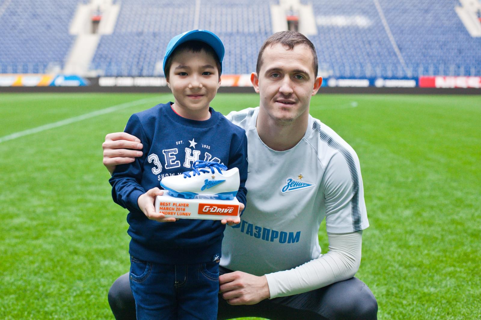 Юный болельщик Мирослав Ахмедов вручает награду «G-Drive. Лучший игрок» футболистам  «Зенита»