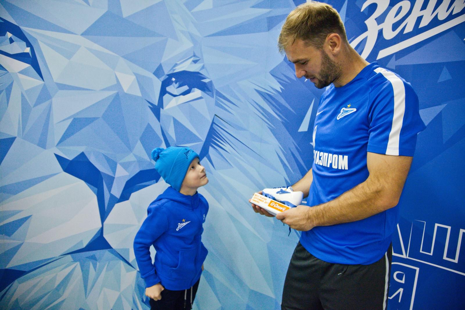 Воспитанник Центра семейного воспитания вручает награду «G-Drive. Лучший игрок сентября» защитнику «Зенита» Браниславу Ивановичу