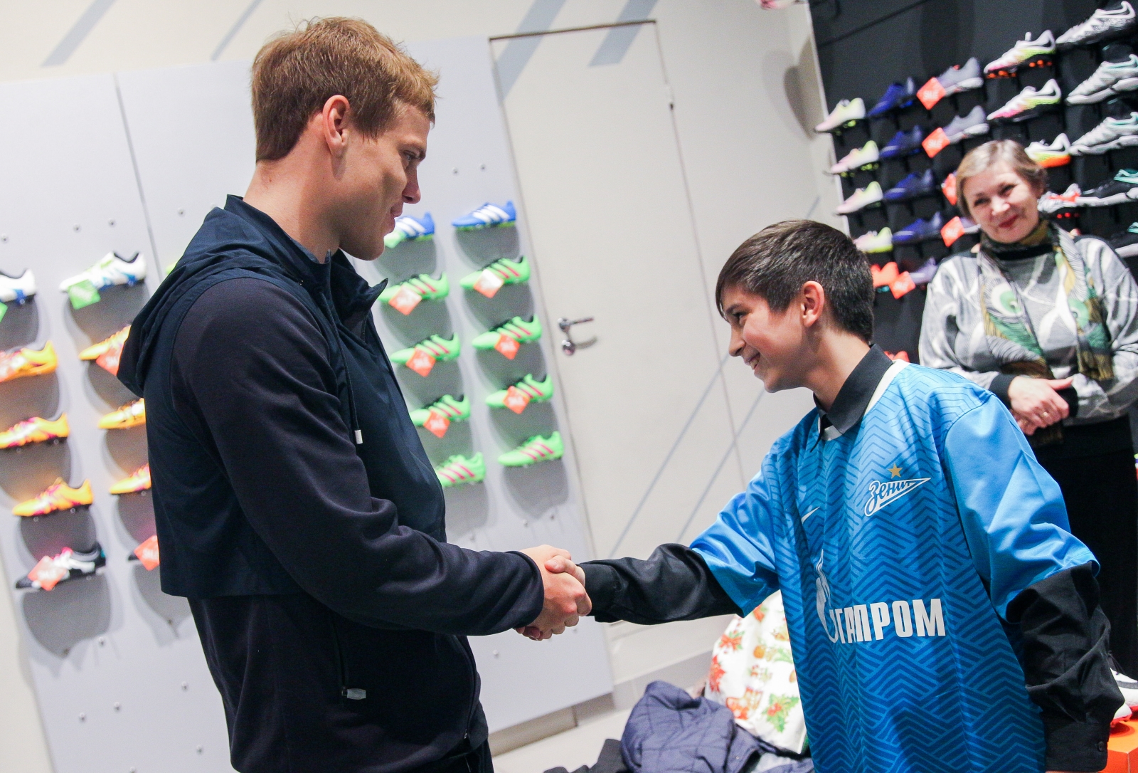 Александр Кокорин выбирает бутсы для воспитанника детдома Даниила Демина