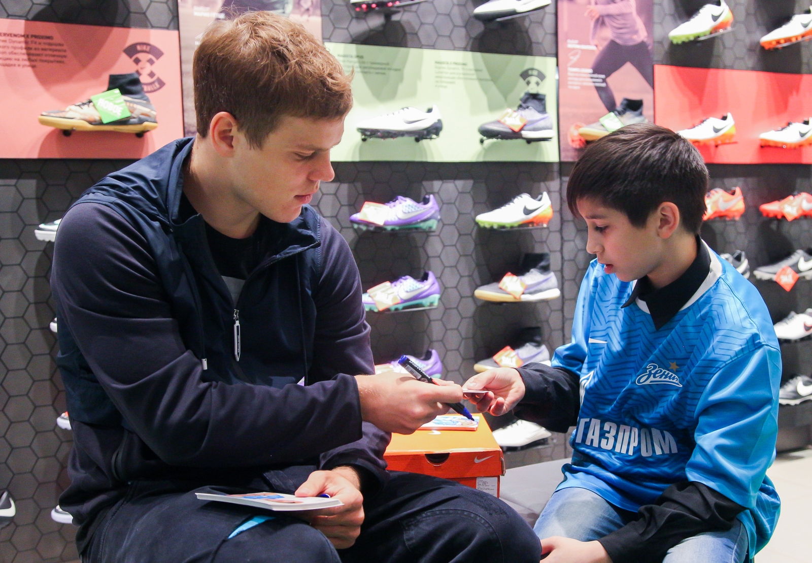 Александр Кокорин выбирает бутсы для воспитанника детдома Даниила Демина