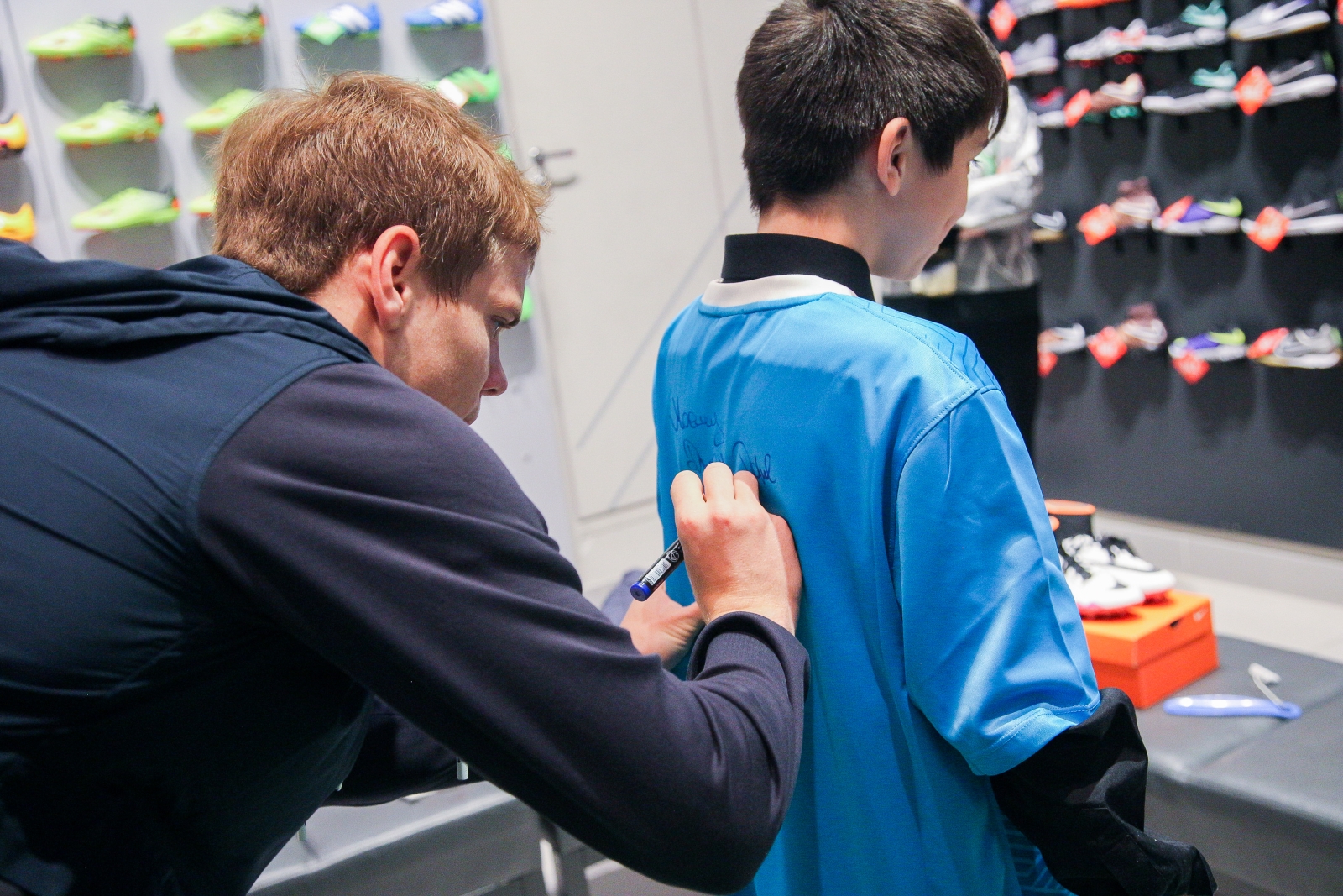 Александр Кокорин выбирает бутсы для воспитанника детдома Даниила Демина